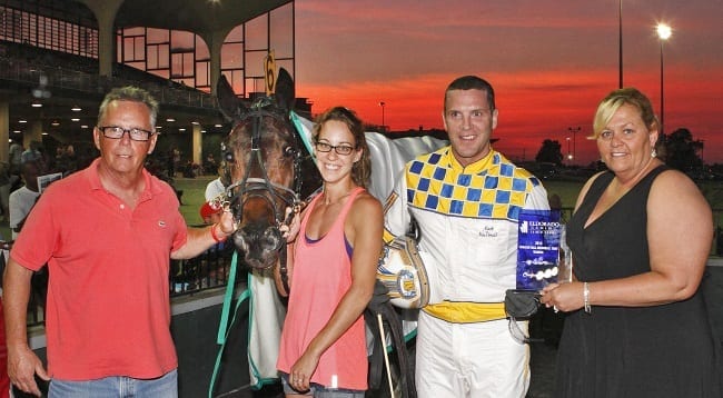Obrigado’s trainer and part-owner Paul Kelley (left) is joined in the Scioto Downs winner’s circle by caretaker Jenna Caligaris and driver Mark MacDonald after winning Saturday's $210,000 Charlie Hill Memorial | Brad Conrad
