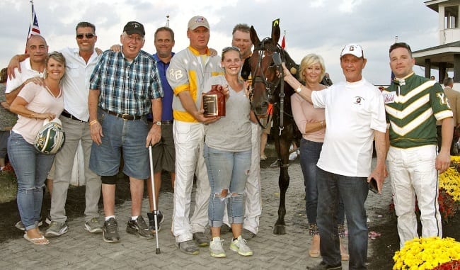 Filibuster Hanover's part-owner Mark Weaver (blue shirt behind Mickey Burke, Sr. and Ron Burke), said he was happy, but a little subdued after the Jug victory. “I have a lot of respect for Brian (Brown) and I know what it’s like to lose races that you are supposed to win,” Weaver said | Brad Conrad